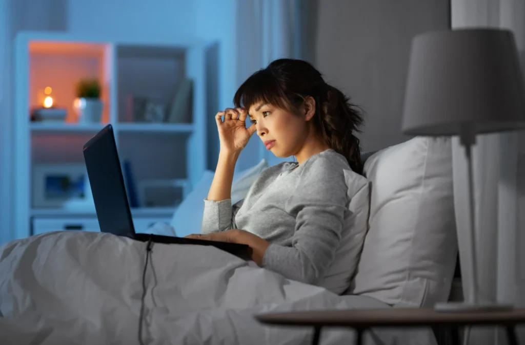 Depression Counseling in Gurgaon 21 stressed woman with laptop working bed night 1 scaled 1