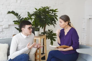 psychology therapy psychiatry mental health counseling concept candid shot nervous self conscious young male glasses telling middle aged female counselor about his problems work 1