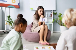 young woman doing speech therapy with kids