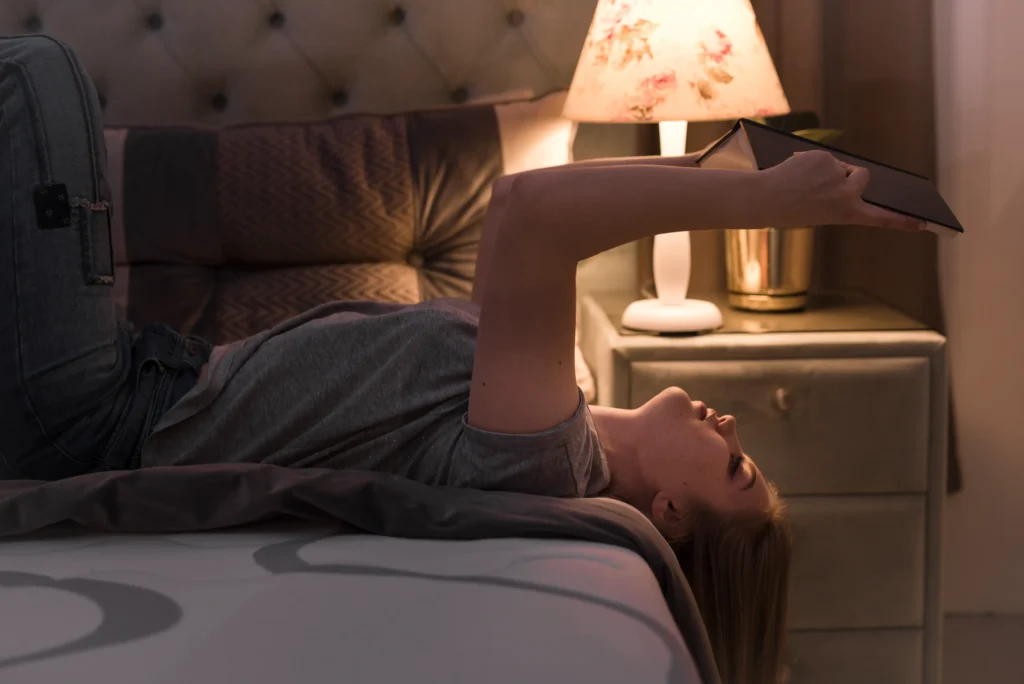 blonde woman laying back bed