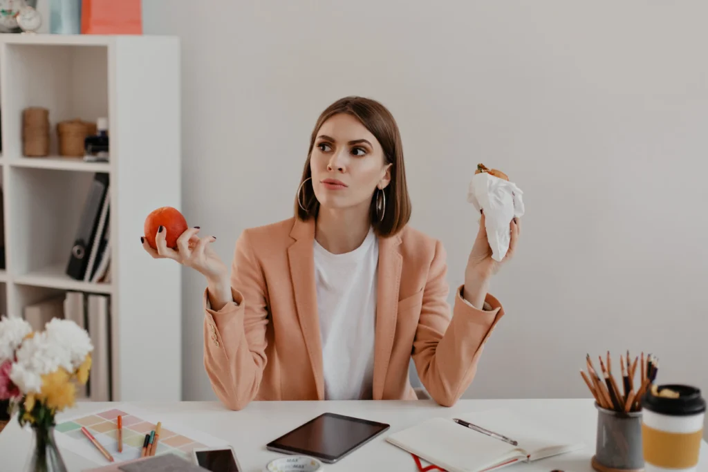 portrait lady with short hair office business woman thought chooses eat burger healthy apple