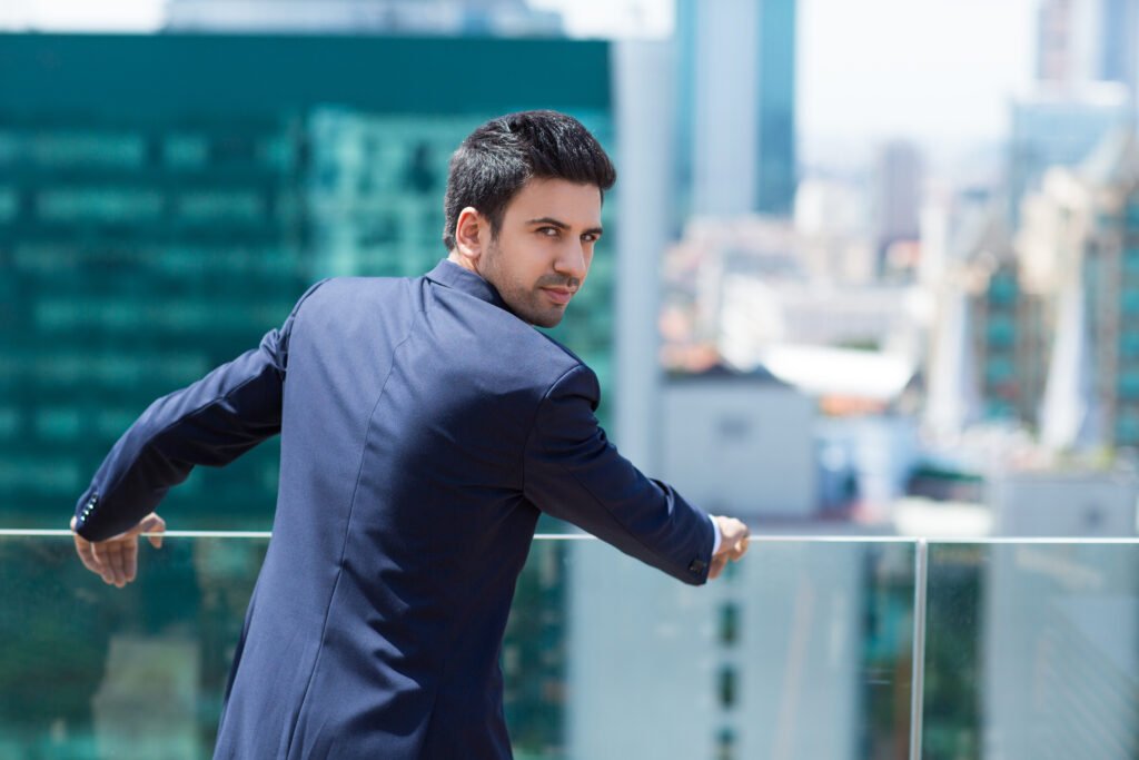 elegant man leaning railing looking back