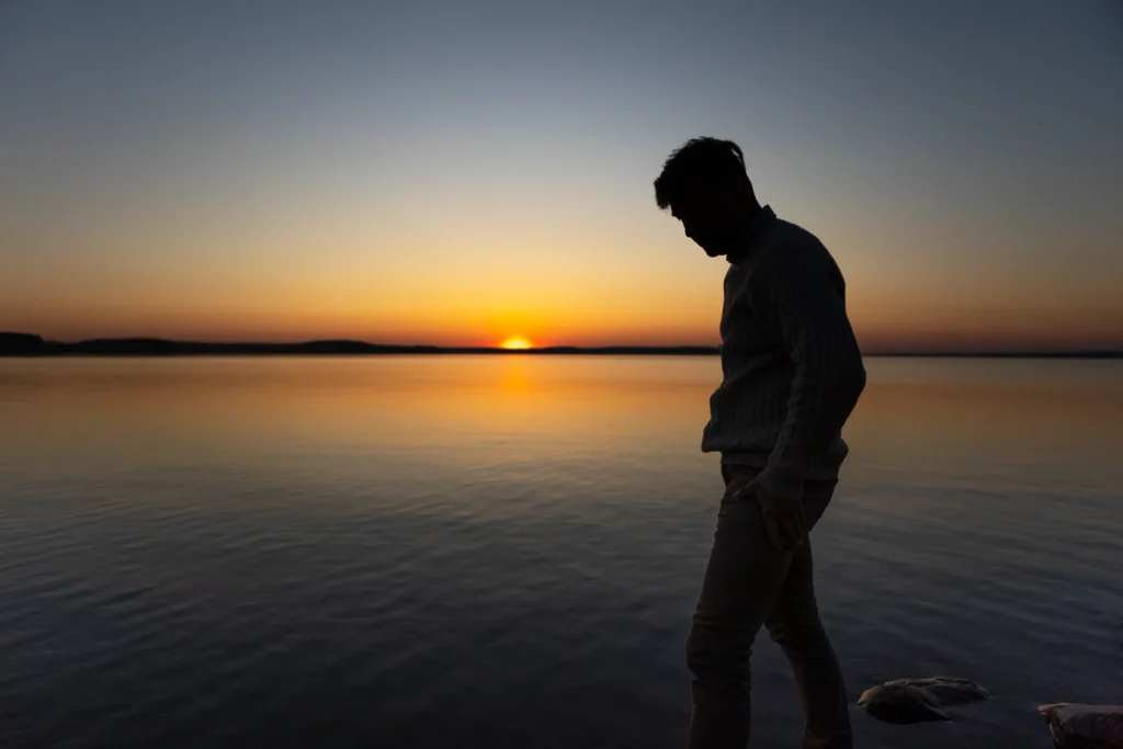 sad contemplative person near lake