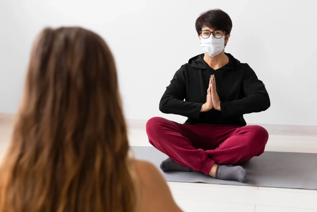 woman meditating with face mask