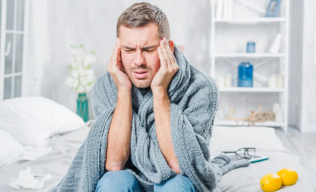 young man suffering from cold having headache scaled e1758966172383