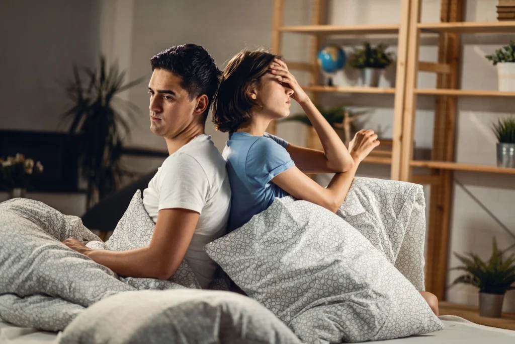 young sad couple ignoring each other while sitting back back bed 1