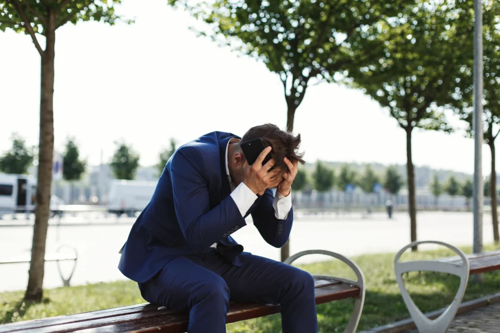 sad businessman sits bank outside street